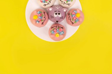 Beyaz tabaktaki kekler, sarı arka plan.