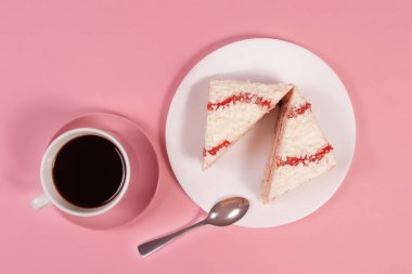 Kahve ve pembe arka planda iki dilim kek, yukarıdan manzara.