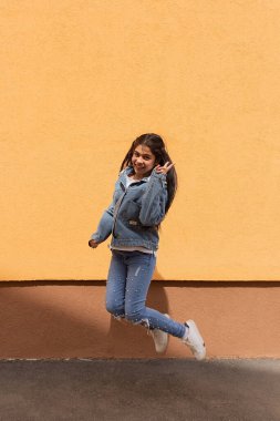 Turuncu duvara doğru atlayan kız.