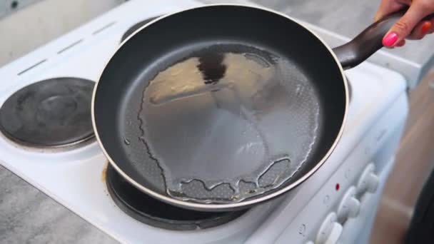 Женщина двигает сковородку с маслом — стоковое видео