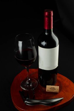 Bardaklı kırmızı şarap şişesi.