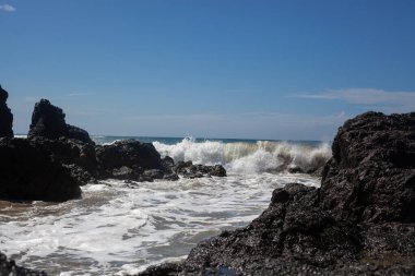 Siyah taşlı okyanus dalgaları. Okyanus ufku