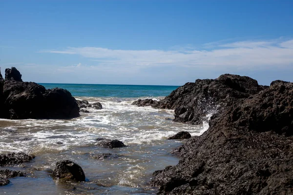Ocean waves with some black rocks. Ocean horizon