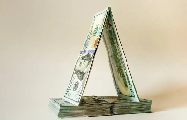 100 dolarlık banknotlar kağıttan bir ev şeklinde katlanır. Tasarruf, planlama, tahminler.