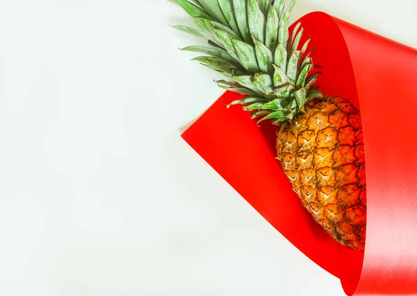 Reife Saftige Ananas Auf Hellem Hintergrund Eine Rote Tüte Gewickelt — Stockfoto