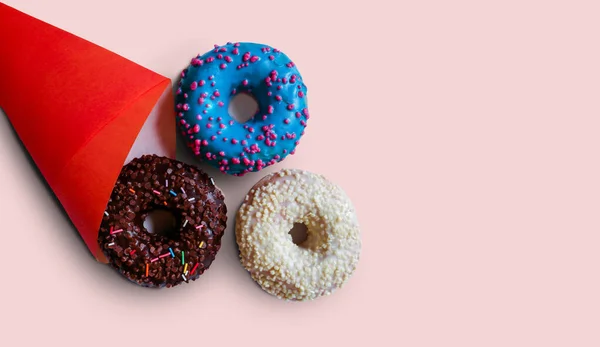 Çikolatalı tatlı, lezzetli çörekler. Kırmızı çantadan mavi ve beyaz jöleler düşüyor. Kopyalamak için boş yer. Lezzetli bir aperatif olarak donut, tatlı tatlı tatlı