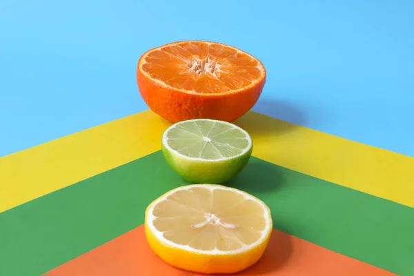 Citrus fruits cut across: orange, lemon and lime on a colored background. Fresh, juicy fruits rich in vitamins, acids and essential oils