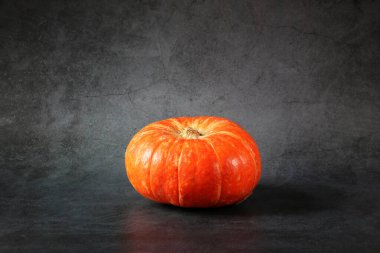 Koyu arkaplanda olgun turuncu balkabağı. Kopyalamak için boş alan.