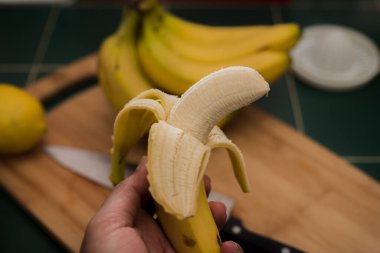 Bir adamın elinde soyulmuş muz