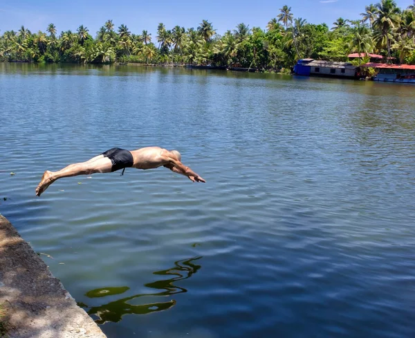 A french man dive in shorts in the backwater of Allepey