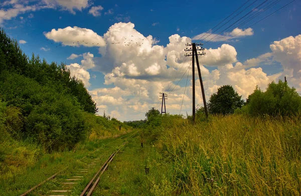 A landscape of abandoned railway track against a cloudy blue sky in small town located in Poland, Europe