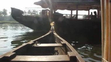 Güney Hindistan 'da Alleppey, Kerala' da güneş ışığının önünden geçen bir tekne.