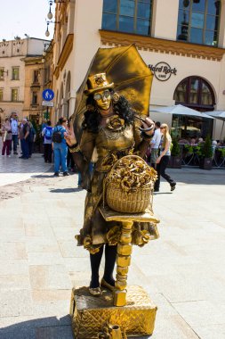Krakow, Polonya - 23 Mayıs 2014: Şehir merkezine turist çekmek için altın rengi giyinmiş bir sokak sanatçısı - Avrupa