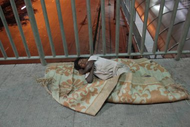 Yeni Delhi, Hindistan - 29 Nisan 2012: Otoyol üstgeçit köprüsünde üniformalı bir çocuk uyuyor