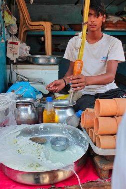 Mathura, Hindistan - 11 Mayıs 2012: Mathura şehrinde Lassi 'yi yoğurttan hazırlayan bir satıcı