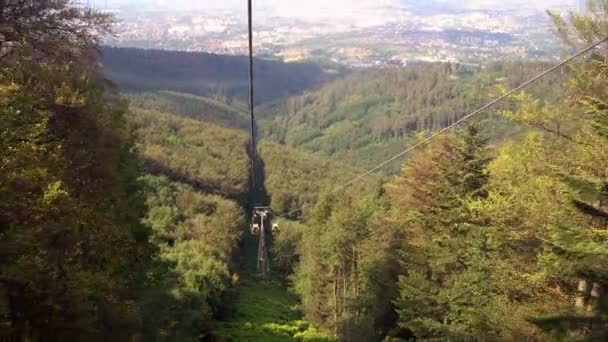 Bielsko Biala, Poland: Wide angle shot of electric yellow cable car moving through forest and mountains — 图库视频影像