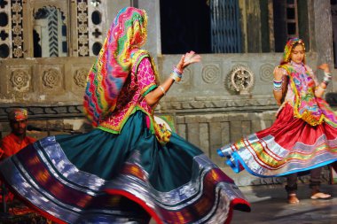 Udaipur, Hindistan - 24 Mayıs 2013: Rajasthan eyaletinde dans eden iki Hintli kadın geleneksel renkli elbiseler içinde