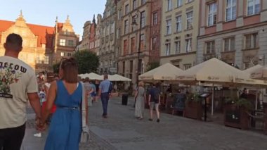 Gdansk, Kuzey Polonya - 15 Ağustos 2020: İnsanlar covid 19 salgınından hemen sonra akşam üzeri şehir merkezindeki Neptün çeşmesinin etrafında boş zaman aktiviteleri yapıyor ve yemek yiyorlar