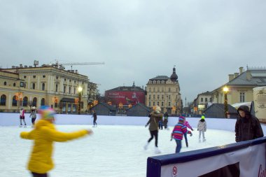 Krakow, Polonya - 30 Kasım 2014: Noel 'de buz pateni yapan çocuklar hatta kış aylarında şehir merkezindeki ana meydanda Galeria Krakowska alışveriş merkezinden önce tatil yapıyorlar