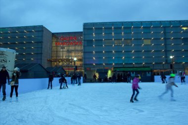 Krakow, Polonya - 30 Kasım 2014: Noel 'de buz pateni yapan çocuklar hatta kış aylarında şehir merkezindeki ana meydanda Galeria Krakowska alışveriş merkezinden önce tatil yapıyorlar