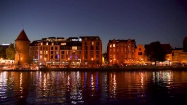 Gdansk, Kuzey Polonya - 15 Ağustos 2020: Polonyalı bir mimarinin gece çekimleri ve covid 19 salgınından hemen sonra Motlawa nehrinin yanında boş vakit harcayan insanlar