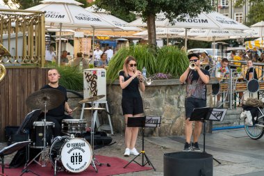 Gdansk, Kuzey Polonya - 13 Ağustos 2020: Eski şehrin şehir merkezinde covid 19 sırasında açık orkestrada enstrüman çalan sokak sanatçısı