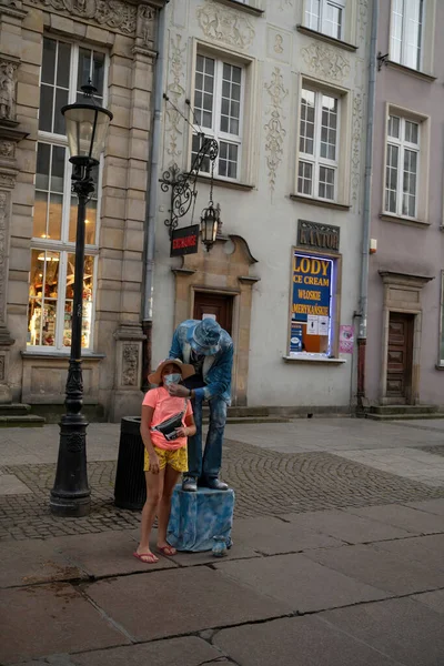 波兰北部格但斯克 2020年8月13日 一名街头男艺人在市中心主广场拍照时给一名女孩固定面具 — 图库照片