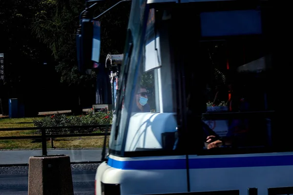 波兰北部格但斯克 2020年8月15日 一名戴着面具和太阳镜的男子穿过公交车窗 在市中心等电车或公共汽车 — 图库照片
