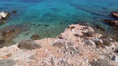 Rodos - Yunanistan: Kristal berrak mavi su üzerinde paslı kayalık tepelere karşı yazın Halki (Chalki) Adası 'nda Ege Denizi' nin eğimli çekimi