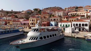 Rodos, Yunanistan: Ege kıyısı kıyısındaki küçük halki / chalki köyündeki dik bir tepe üzerindeki geleneksel çok renkli evlerin Emboria limanından Pan çekimi