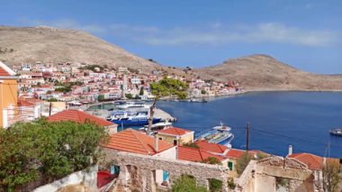 Rodos, Yunanistan: Ege deniz kıyısındaki Halki / chalki adasındaki dik bir tepenin üzerindeki geleneksel çok renkli evlerin çekimleri