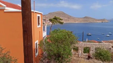 Rodos, Yunanistan: Ege kıyısı kıyısındaki dik bir tepenin üzerindeki Halki / chalki adasının dar sokaklarından geçen mavi bir minibüs