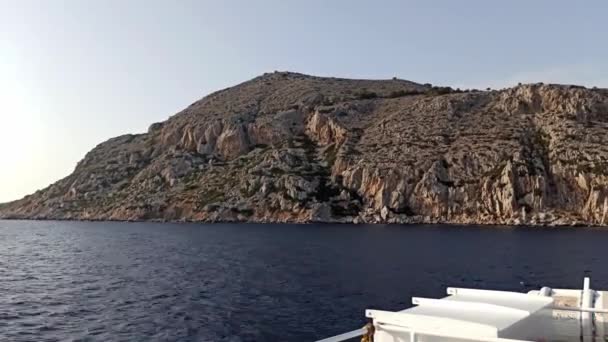 로도스 서쪽에 바위투성이 카메라가 그리스 국기를 천천히 서성거리고 — 비디오