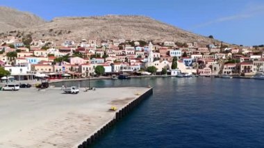 Halki / chalki Adası 'ndaki Emporio limanının ve Rodos' un yaklaşık 6 km batısındaki Dodecanese takımadasındaki Yunanistan tepelerindeki evlerin Pan çekimi
