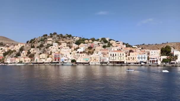 ギリシャのロードス島 ギリシャの島 シミ島のパンショット ドデカネス島グループの一部と船は カラフルな新古典主義の家に囲まれて シミ町の港にドッキング — ストック動画