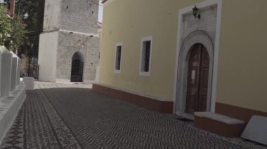 Symi, Yunanistan - 25 Eylül 2020: Akdeniz kıyısında yer ve ortaçağ kilisesinin üzerine oyulmuş Yunan tasarımı. Sınıflandırılmamış / düz çalışma profili.