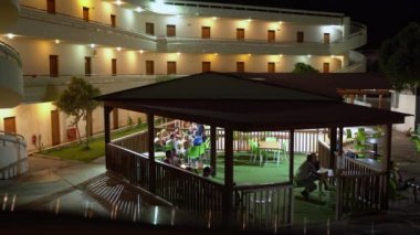 Rodos, Yunanistan - 25 Eylül 2020: Turistler tatilleri boyunca bir otelde gece vakti grup halinde oturup alkol içiyorlar