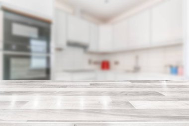 Beyaz ahşap tezgahı olan modern, parlak bir mutfak. 