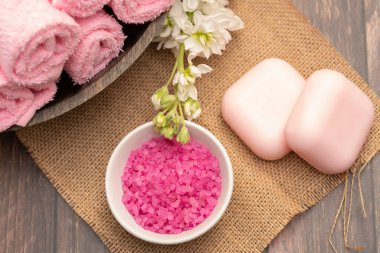 Pembe spa aksesuarları, sabun havluları ve banyo tuzu.