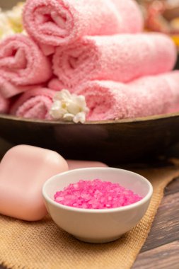 Pembe spa aksesuarları, sabun havluları ve tuz.