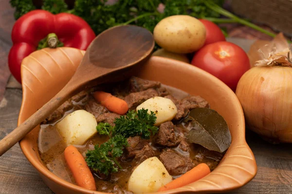 Patates, havuç ve baharatla seramik kapta pişirilmiş sığır eti güveci.