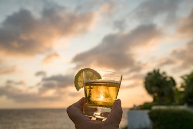 Günbatımında, Curacao Okyanusu 'nun kıyısında içiyor.