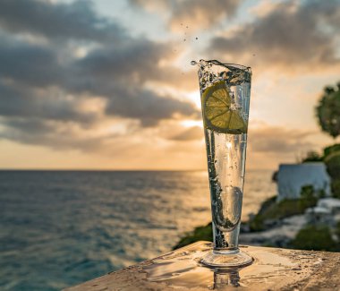 Günbatımında, Curacao Okyanusu 'nun kıyısında içiyor.