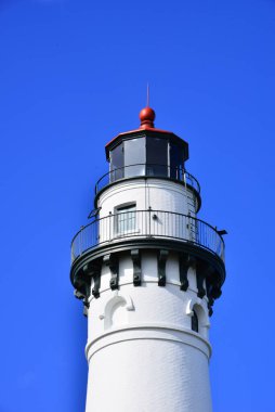 Racine Wisconsin Gölü 'nün kuzeyindeki Rüzgâr Noktası Deniz Feneri' nin işaret kulesi Michigan Gölü 'nün üzerinde kırmızı ışıklı çubuğun üzerinde güzel bulutsuz mavi gökyüzü görünüyor..