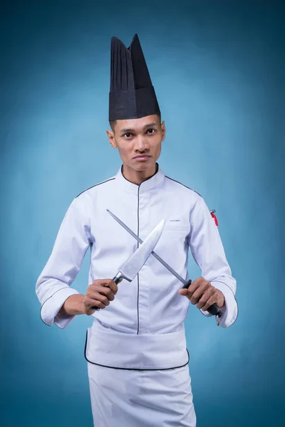 Beyaz Üniformalı Önlüklü Mavi Arka Planda Şapkasız Bıçakla Oynayan Asyalı — Stok fotoğraf