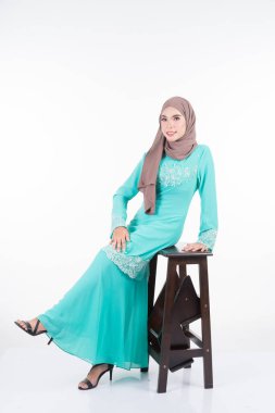Çeşitli pozlarda güzel bir Müslüman kadın model, beyaz tenli Müslüman kadınlar için modern bir yaşam tarzı olan kurung ve tesettür giyiyor. Güzellik ve tesettür moda konsepti. Tam boy portre