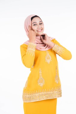 Çeşitli pozlarda güzel bir Müslüman kadın model, beyaz arka planda izole edilmiş Müslüman kadınlar için modern bir yaşam tarzı olan kurung ve tesettür giyiyor. Güzellik ve tesettür moda konsepti. Yarım boy portre