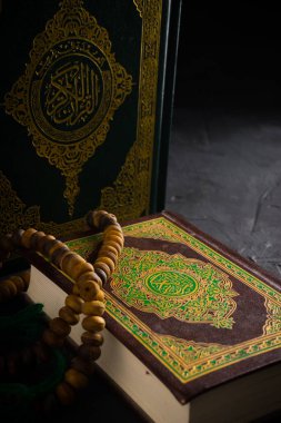 İslam kavramına olan inanç. İslam kutsal kitabı Kuran ya da Kuran 'da tespih boncukları ya da koyu arkaplanda tasbih..