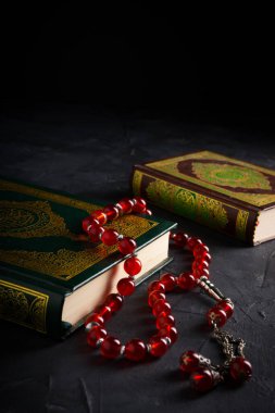İslam kavramına olan inanç. İslam kutsal kitabı Kuran ya da Kuran 'da tespih boncukları ya da koyu arkaplanda tasbih..