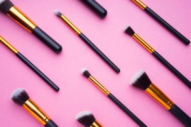 Pembe arka planda kozmetik ürünlerinin yaratıcı düzenlenmesi.